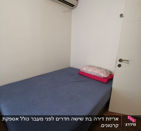 מיטה עם מצעים כחולים ומזגן על הקיר